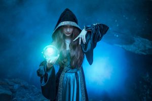 Hooded witch with a glowing blue orb