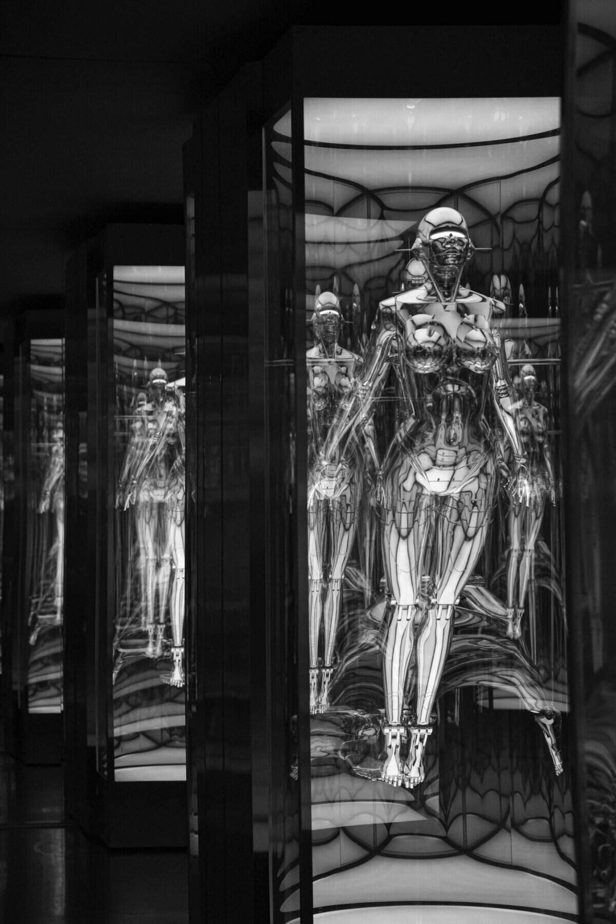 black and white photo of an android behind a glass window