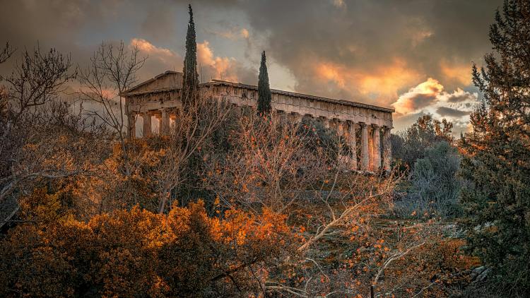 photo of a Greek temple surrounded by plants and trees