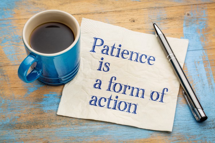 Patience is a form of action - inspirational handwriting on a napkin with a cup of espresso coffee