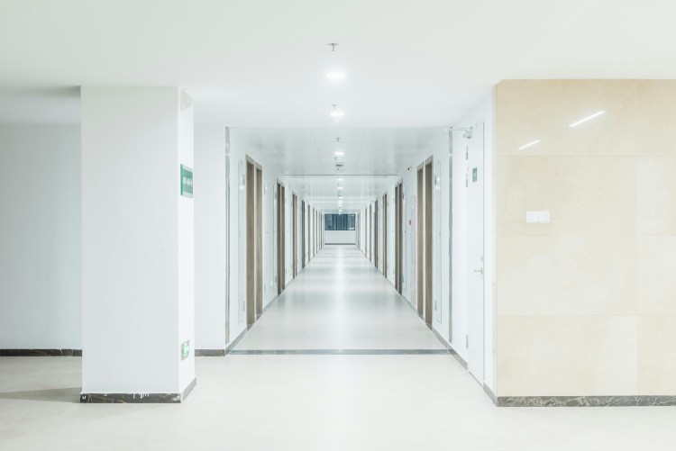 a long empty hallway with white walls 