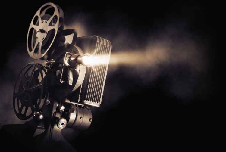 Movie projector on a dark background with light beam / high contrast image