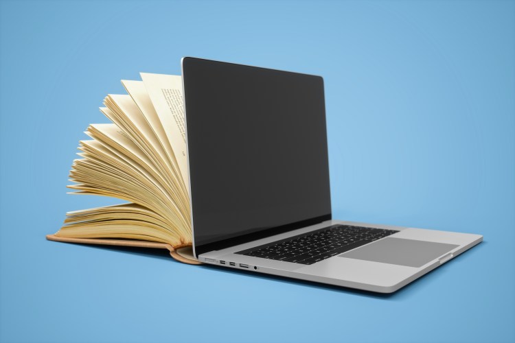 book is better than movie concept; a laptop against a blue background with an open book coming out of the back of the screen